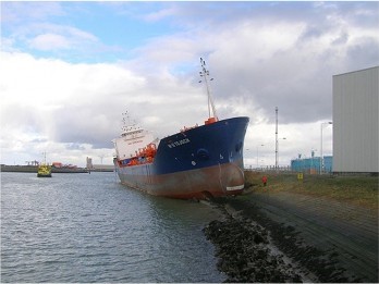 Foto waarop een schip is vastgelopen op teenbestorting en dijkbekleding