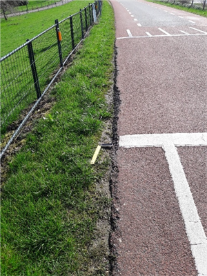 Foto van overgang berm links en asfaltweg rechts.