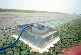 Foto van een apparaat dat de toplaagdoorlatendsheid meet geplaatst op een talud.