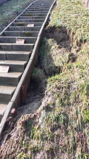 Foto van weggeslagen gras naast een trap.