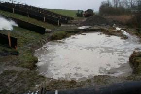 Foto van waterplas onderaan een talud.