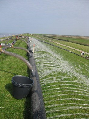 Foto van infiltratie met water op een dijktalud.